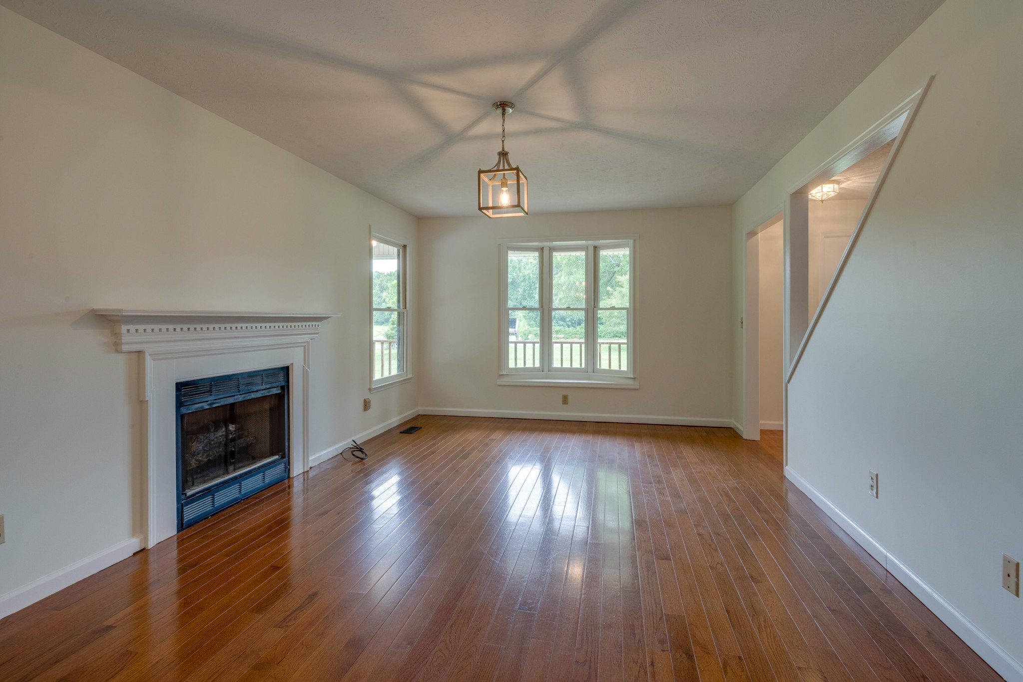 146 Howard Road White Bluff, TN 37187 - Photo 7 of 25 an empty room with wooden floor fireplace and windows