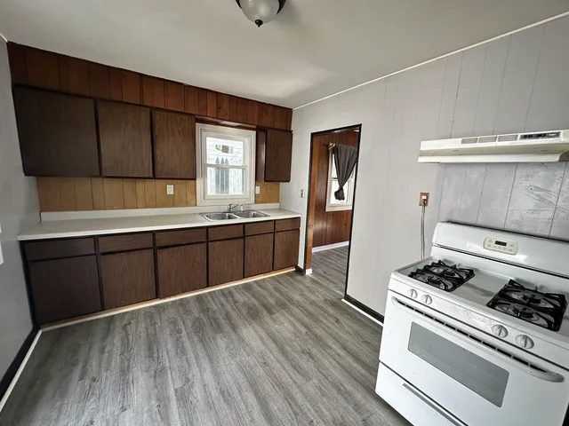 a kitchen with stainless steel appliances hardwood floor sink stove and refrigerator