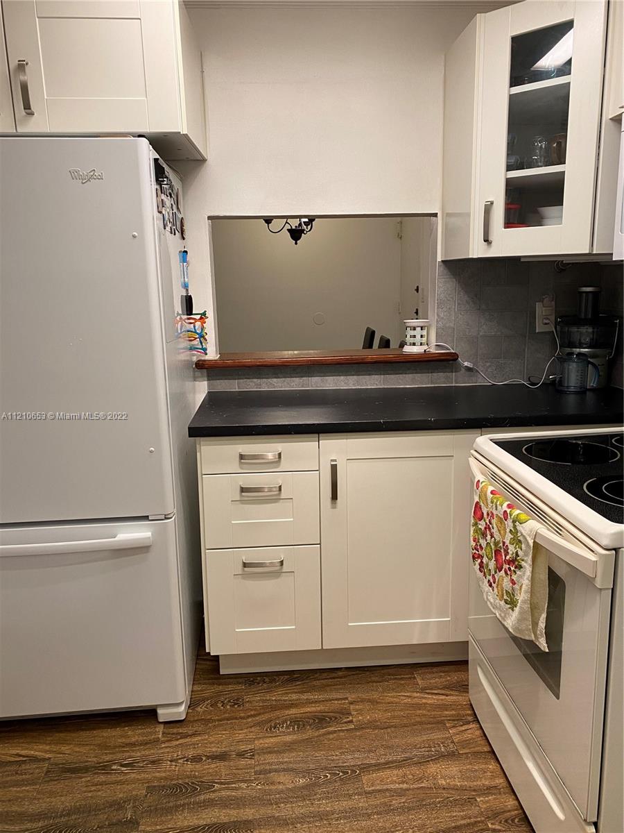 13700 Southwest 62nd Street, Unit 149 Miami, FL 33183 - Photo 11 of 36 a kitchen with granite countertop white cabinets and white appliances