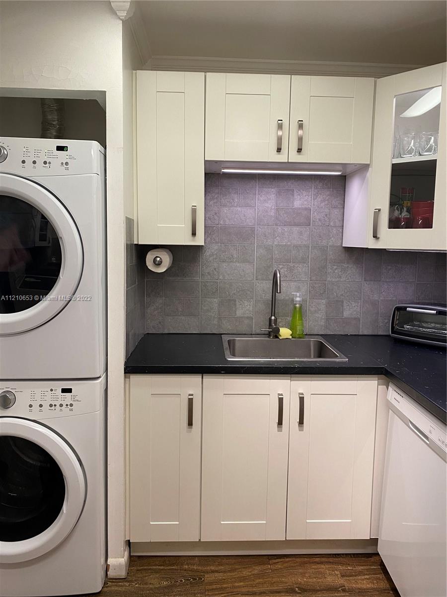 13700 Southwest 62nd Street, Unit 149 Miami, FL 33183 - Photo 13 of 36 a kitchen with a sink a stove and cabinets