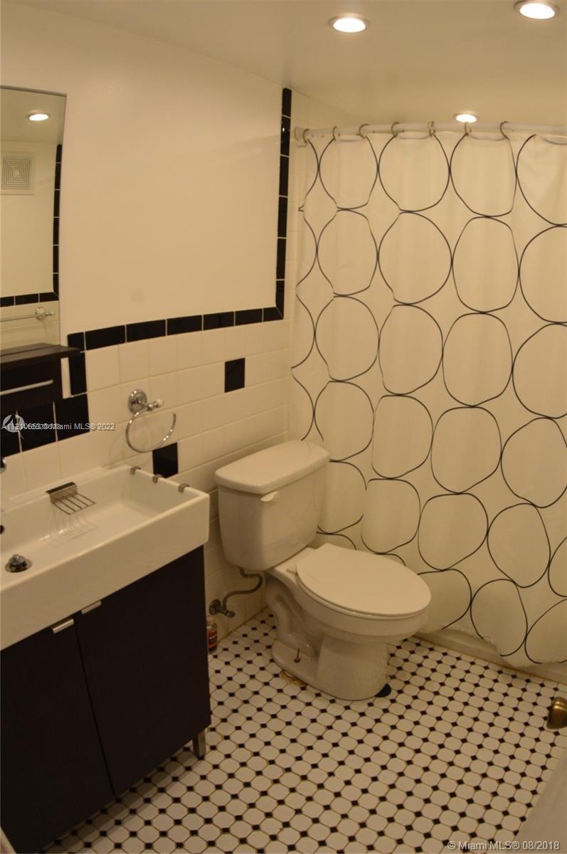 13700 Southwest 62nd Street, Unit 149 Miami, FL 33183 - Photo 19 of 36 a bathroom with a toilet a sink and a mirror