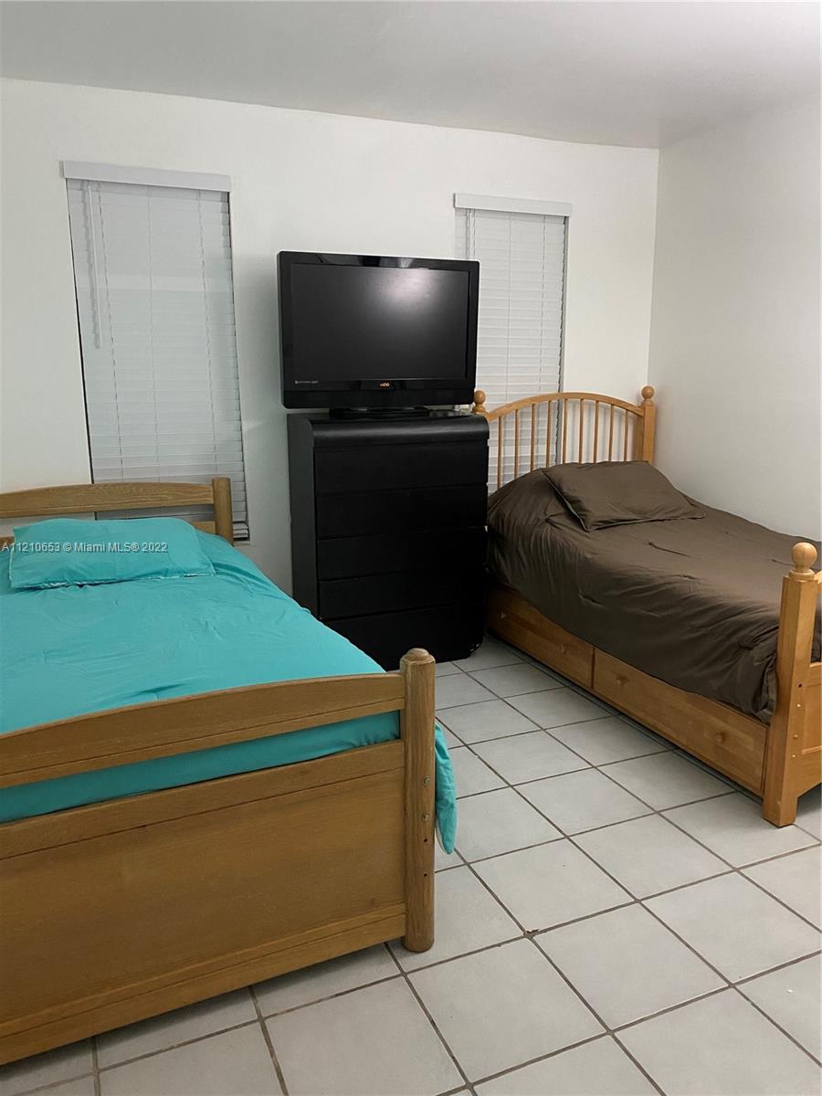 13700 Southwest 62nd Street, Unit 149 Miami, FL 33183 - Photo 20 of 36 a bedroom with a bed and a television