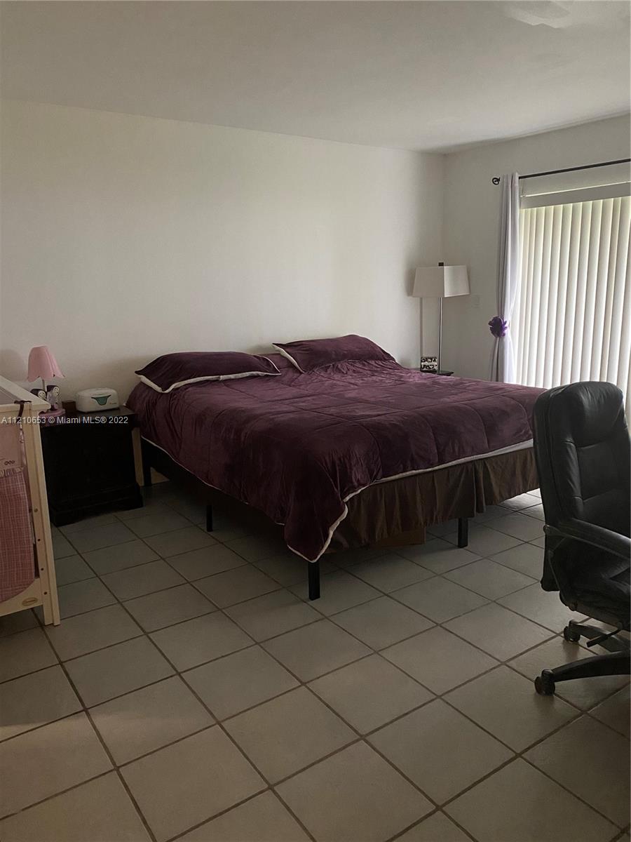 13700 Southwest 62nd Street, Unit 149 Miami, FL 33183 - Photo 24 of 36 a bedroom with a bed and a chair in it