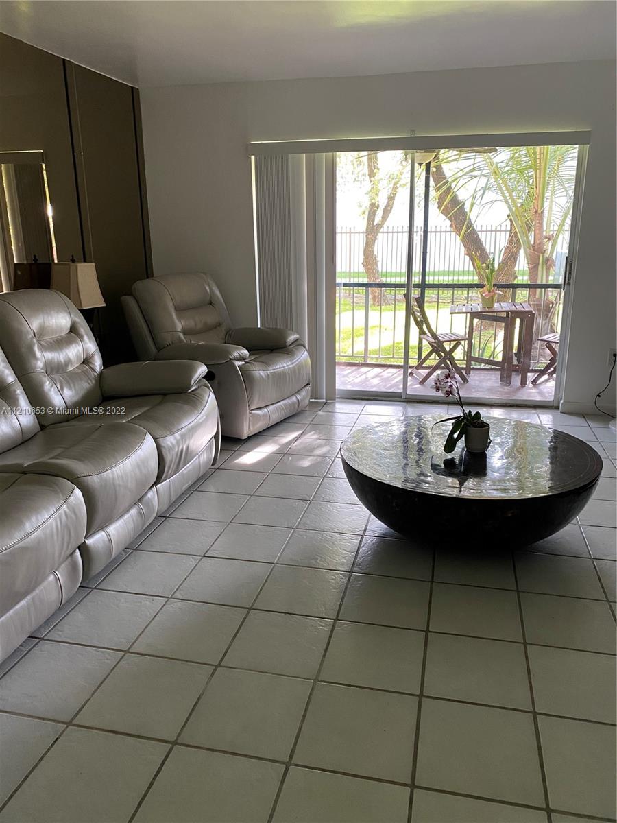 13700 Southwest 62nd Street, Unit 149 Miami, FL 33183 - Photo 6 of 36 a living room with a couch and a table