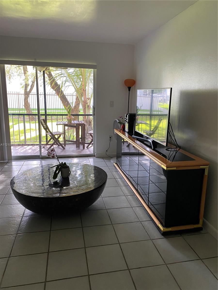 13700 Southwest 62nd Street, Unit 149 Miami, FL 33183 - Photo 8 of 36 a living room with a couch and a flat screen tv