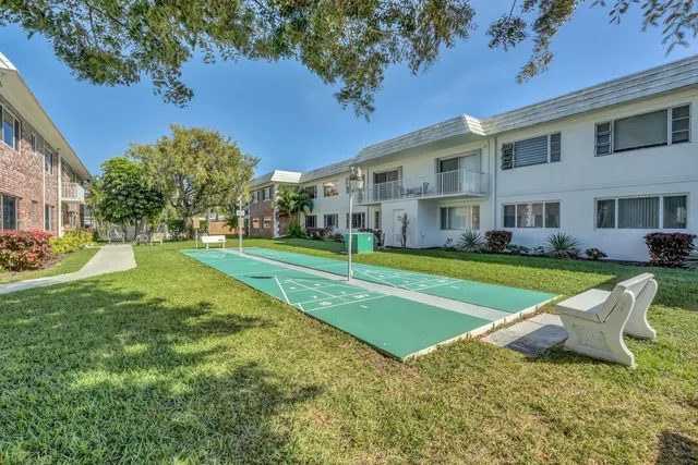 a view of a house with a big yard and large trees