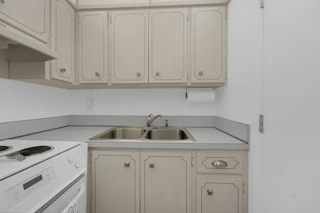 a kitchen with white cabinets and a white stove