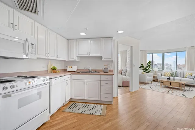 a kitchen with granite countertop white cabinets and white appliances