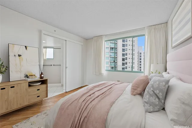 a bedroom with a bed a window and a mirror