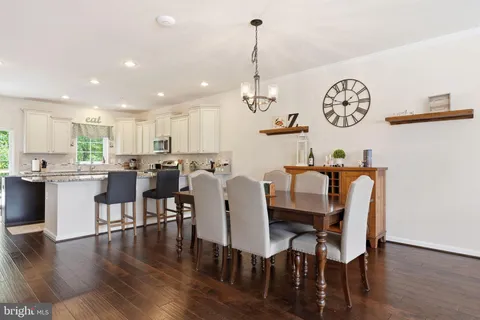 a view of a dining room with furniture a kitchen and chandelier