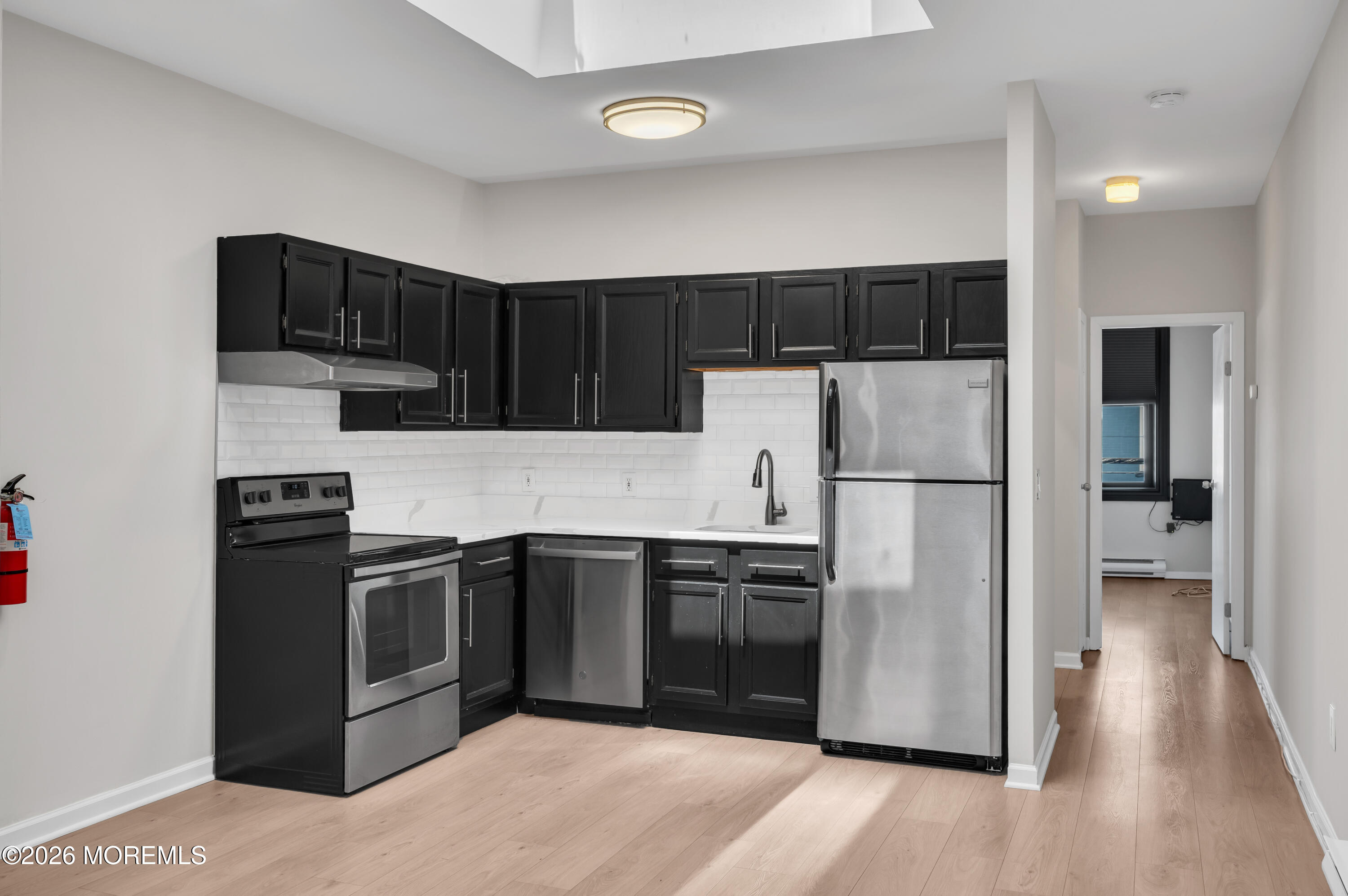 31-33 East Front Street, Unit 2 Red Bank, NJ 07701 - Photo 12 of 21 a kitchen with stainless steel appliances granite countertop a refrigerator and a stove