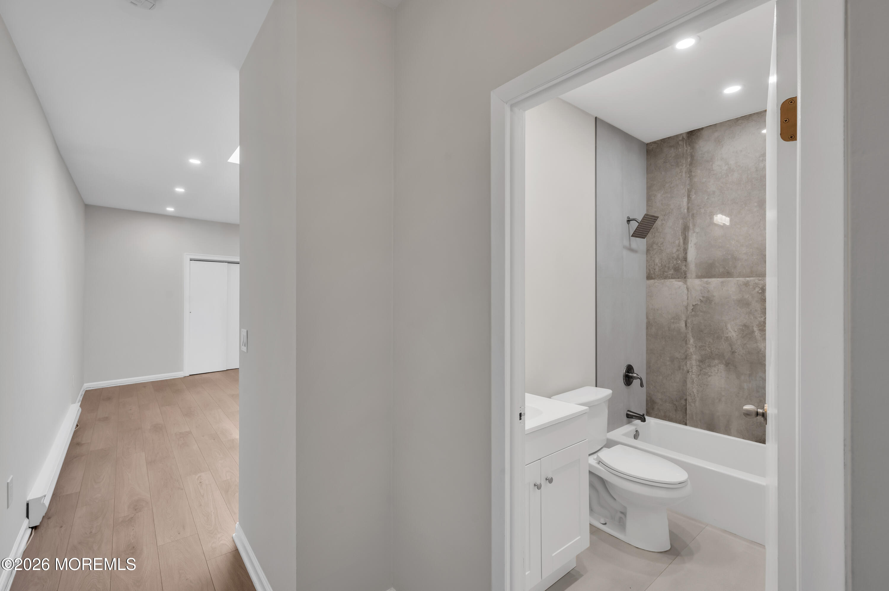 31-33 East Front Street, Unit 2 Red Bank, NJ 07701 - Photo 18 of 21 a bathroom with a granite countertop toilet a sink and a mirror