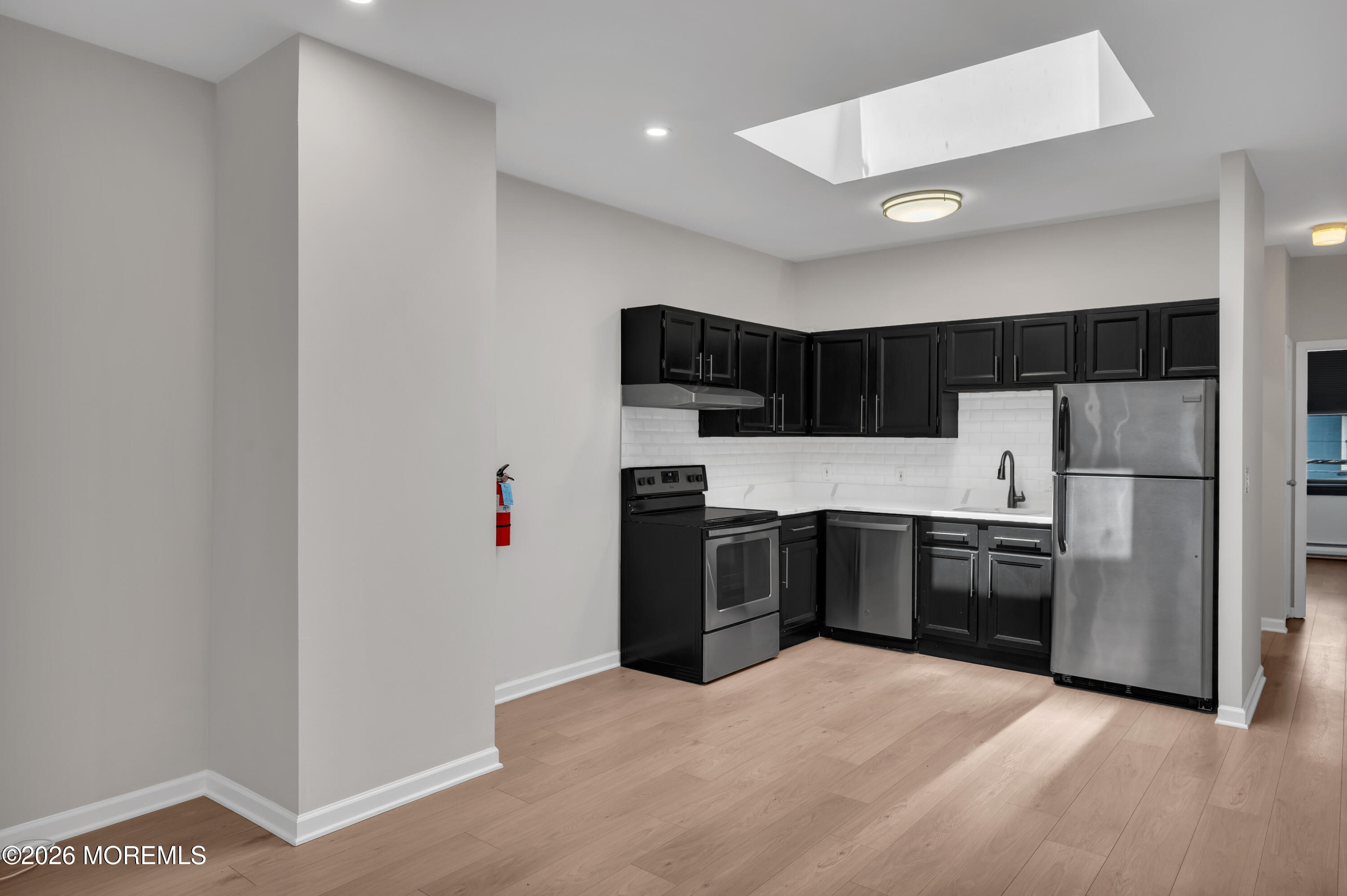 31-33 East Front Street, Unit 2 Red Bank, NJ 07701 - Photo 8 of 21 a kitchen with granite countertop stainless steel appliances and refrigerator