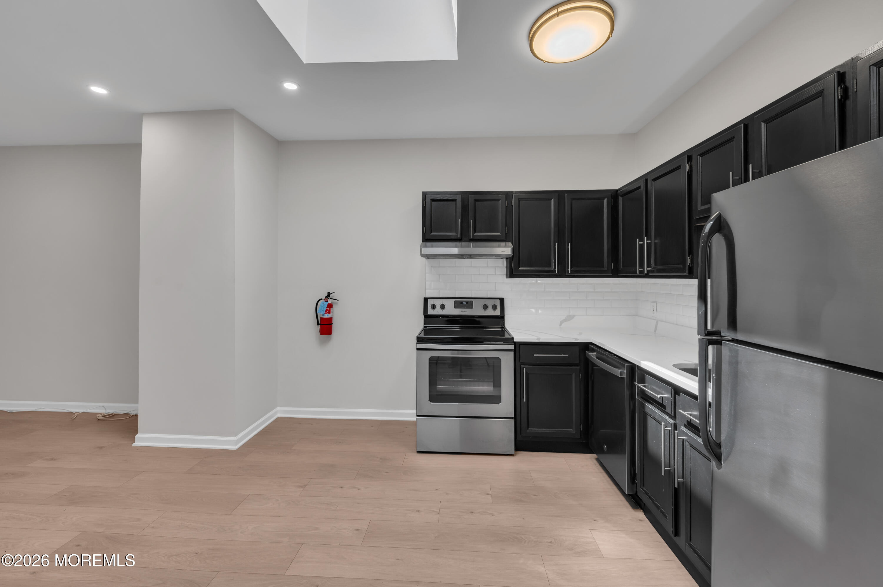 31-33 East Front Street, Unit 2 Red Bank, NJ 07701 - Photo 9 of 21 a kitchen with granite countertop a refrigerator a stove a sink and dishwasher