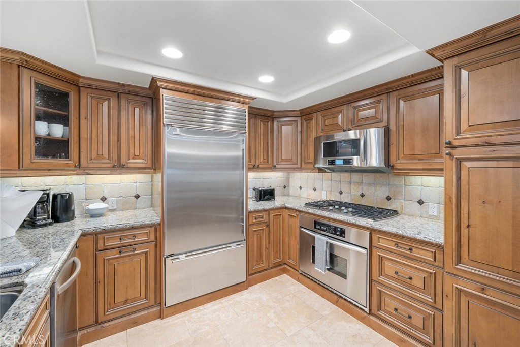 160 Hinds Avenue, Unit 202 Pismo Beach, CA 93449 - Photo 11 of 47 a kitchen with stainless steel appliances granite countertop a stove top oven a sink dishwasher a refrigerator and cabinets with wooden floor