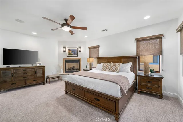 a spacious bedroom with a bed and a flat screen tv