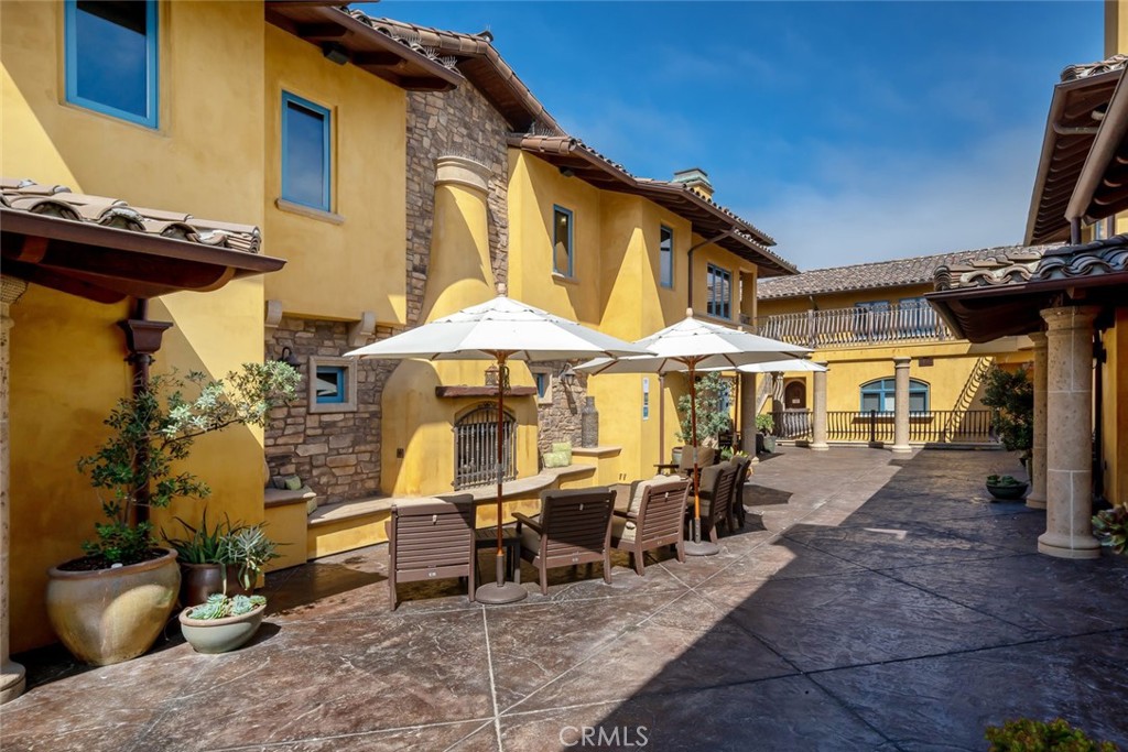 160 Hinds Avenue, Unit 202 Pismo Beach, CA 93449 - Photo 44 of 47 a view of a patio with table and chairs under an umbrella