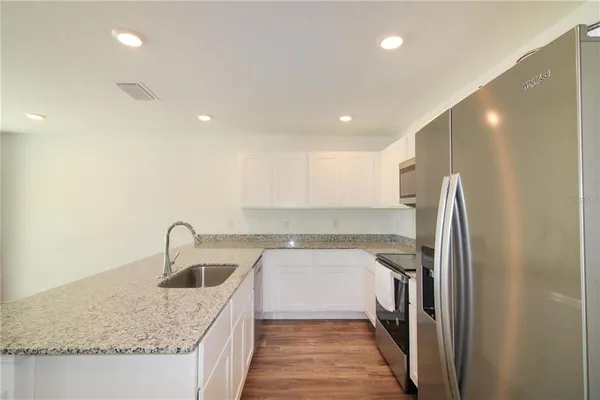 a kitchen with a sink a refrigerator and cabinets
