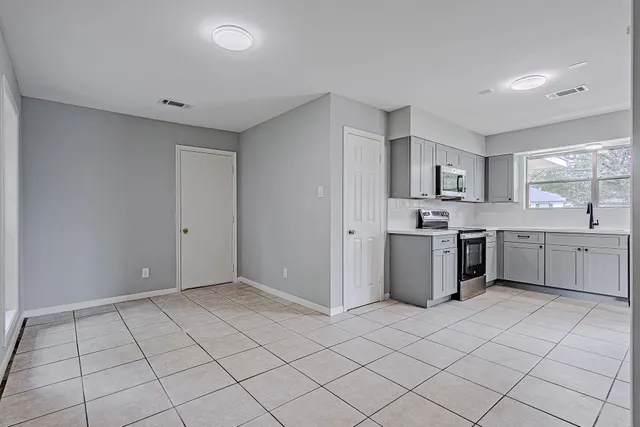 a view of kitchen with a sink cabinets and window