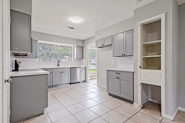a kitchen with white cabinets a sink and white appliances