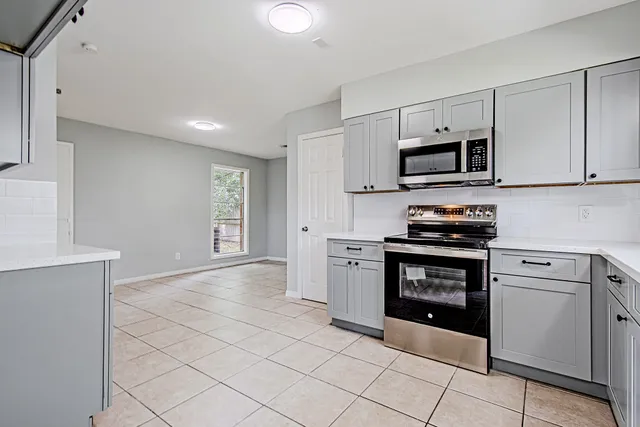 a kitchen with stainless steel appliances granite countertop a stove a sink and a microwave
