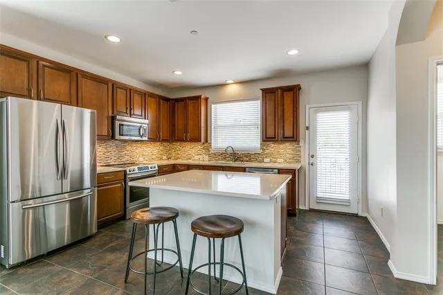 a kitchen with stainless steel appliances granite countertop a refrigerator and a stove top oven