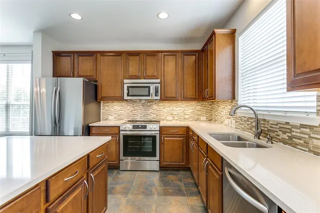 a kitchen with stainless steel appliances granite countertop a sink stove and refrigerator