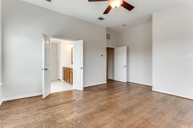 wooden floor in an empty room with a ceiling fan