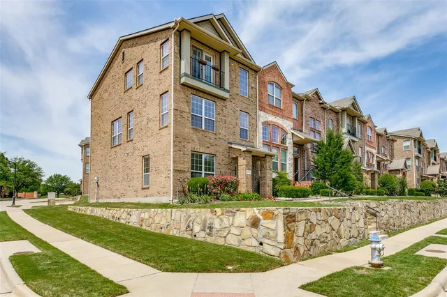 a front view of a residential apartment building with a yard