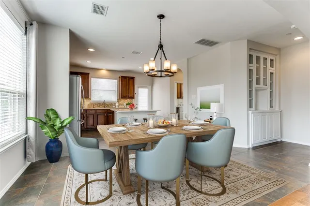 a dining room with furniture potted plants and wooden floor