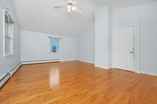 a view of empty room with wooden floor