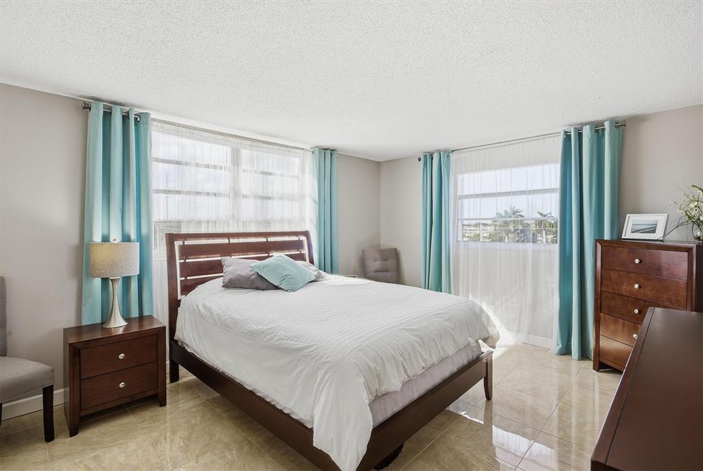 311 Southeast 3rd Street, Unit 410 Dania Beach, FL 33004 - Photo 18 of 51 a bedroom with a bed and large windows
