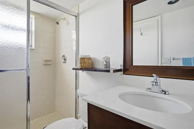 a bathroom with a sink and mirror with toilet