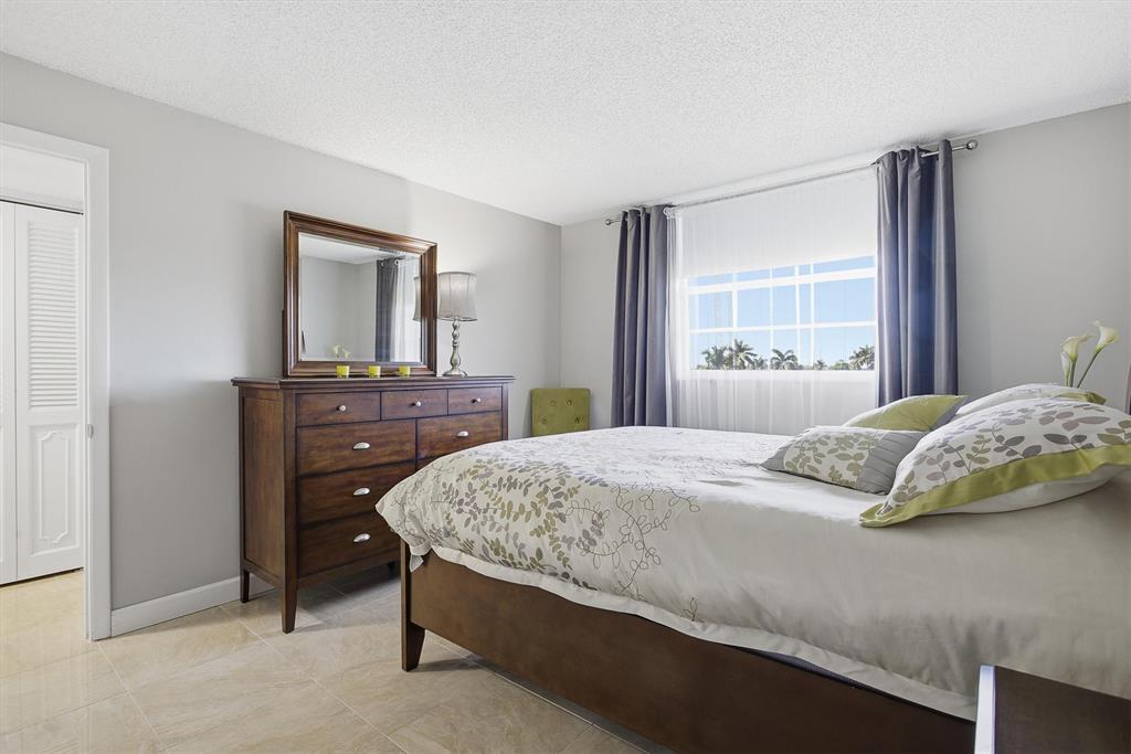 311 Southeast 3rd Street, Unit 410 Dania Beach, FL 33004 - Photo 25 of 51 a bedroom with a bed and a dresser