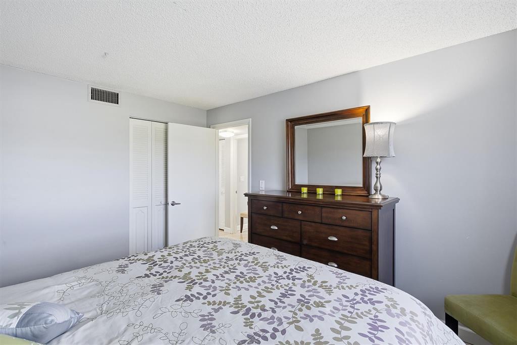 311 Southeast 3rd Street, Unit 410 Dania Beach, FL 33004 - Photo 26 of 51 a bedroom with a bed and a mirror