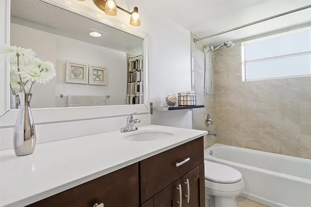 a bathroom with a sink a toilet tub and shower