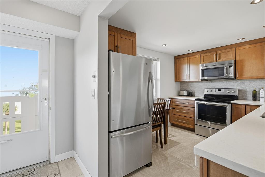 311 Southeast 3rd Street, Unit 410 Dania Beach, FL 33004 - Photo 3 of 51 a kitchen with stainless steel appliances a refrigerator and a stove top oven