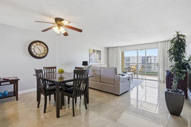 a view of a livingroom and a dining room with furniture wooden floor and a clock
