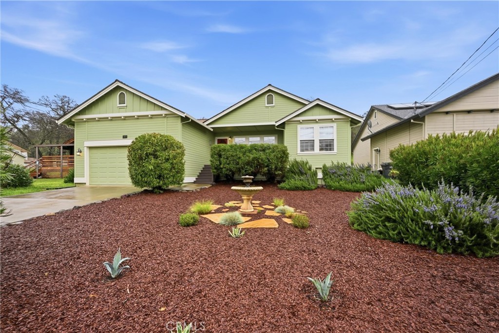 a view of a house with a yard and large trees