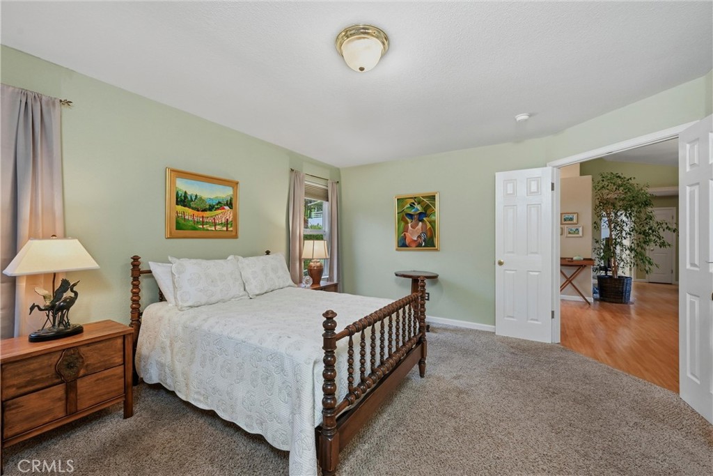 19072 Hidden Valley Road Hidden Valley Lake, CA 95467 - Photo 12 of 27 a bedroom with a bed and a chandelier