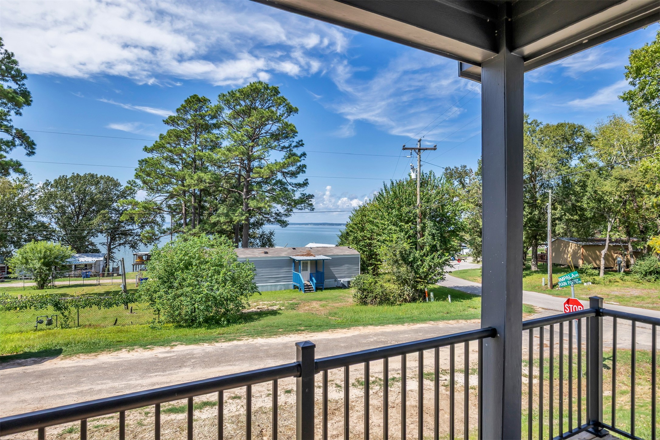 117 Rain Forest Road Onalaska, TX 77360 - Photo 8 of 30 Enjoy serene lake views from this spacious balcony, perfect for relaxing amid lush greenery and tranquil surroundings.