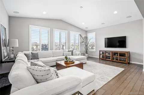 a living room with furniture and a wooden floor