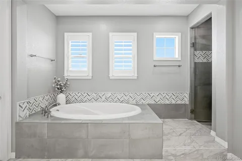 a spacious bathroom with a double vanity sink a mirror and a bathtub