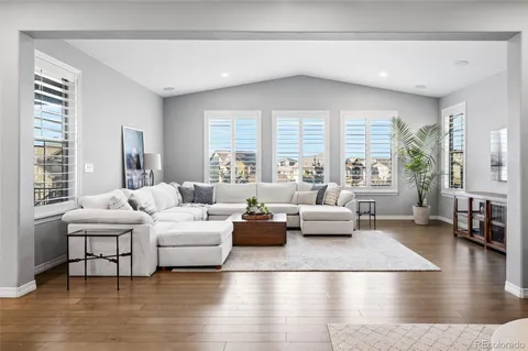 a kitchen with kitchen island granite countertop a stove a sink and white cabinets with wooden floor