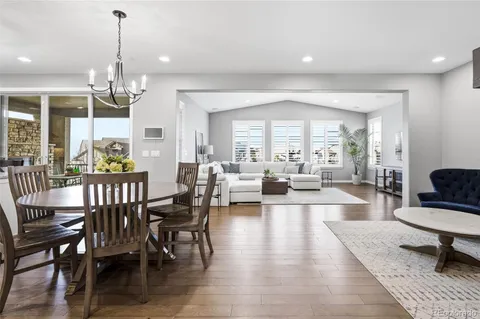 a view of kitchen island with wooden floor dining table and chairs