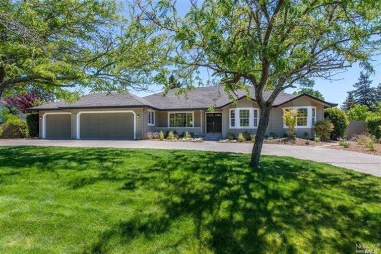a front view of a house with yard and green space