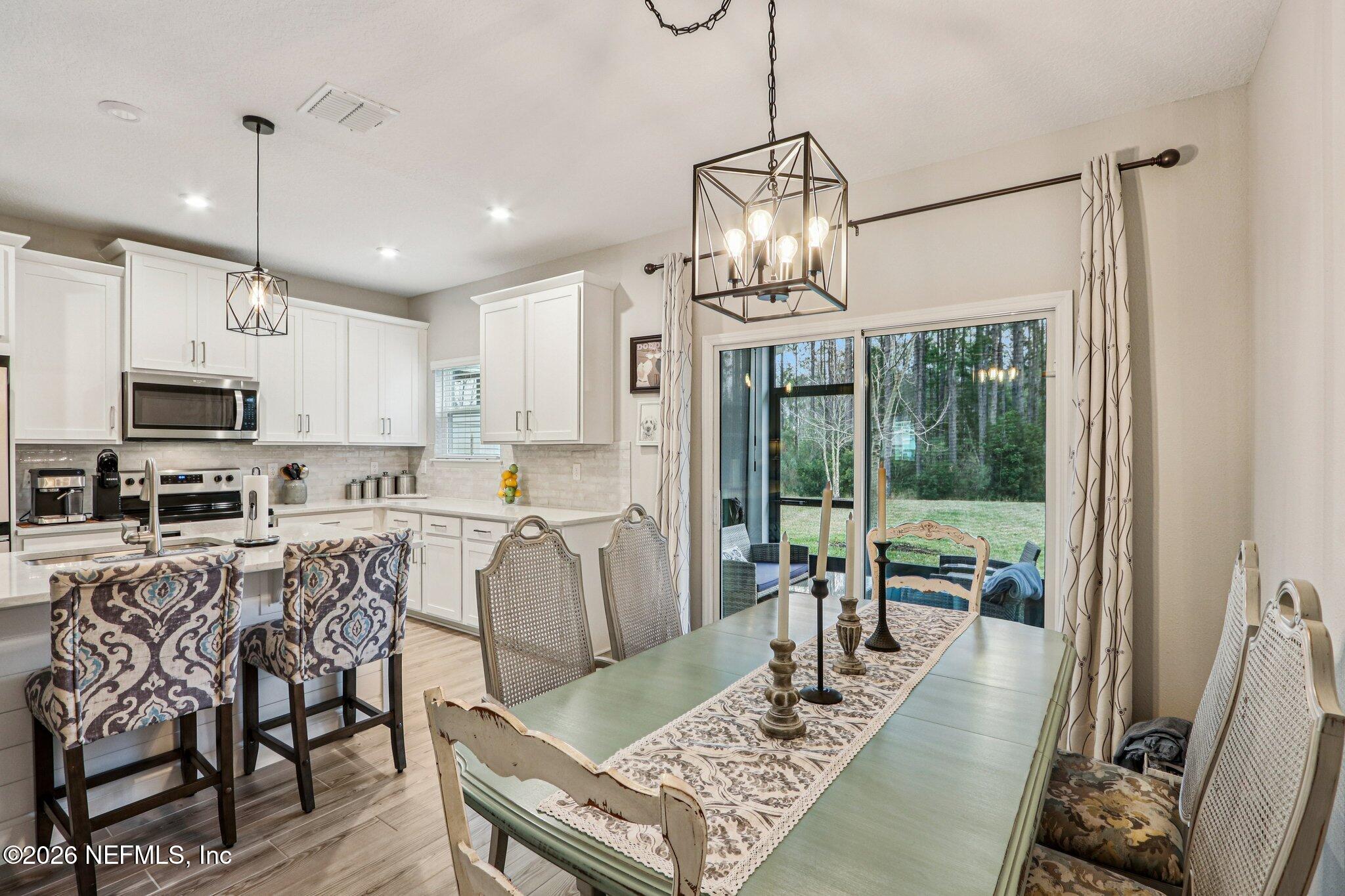 12068 Calvesta Street Jacksonville, FL 32256 - Photo 12 of 100 a view of a dining room with furniture wooden floor and chandelier