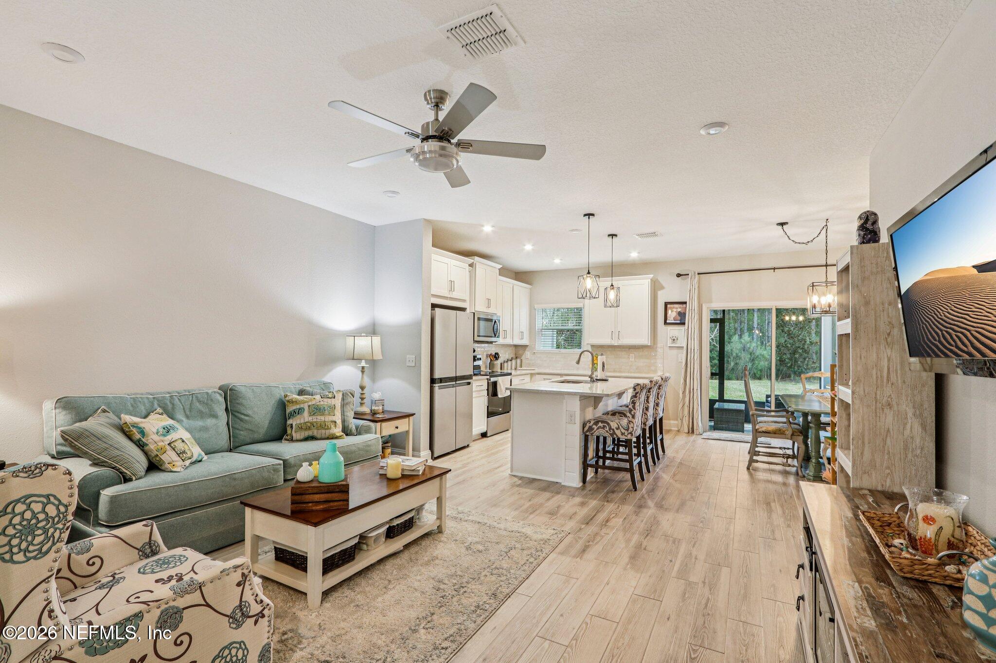 12068 Calvesta Street Jacksonville, FL 32256 - Photo 20 of 100 a living room with furniture and a dining table with kitchen appliances