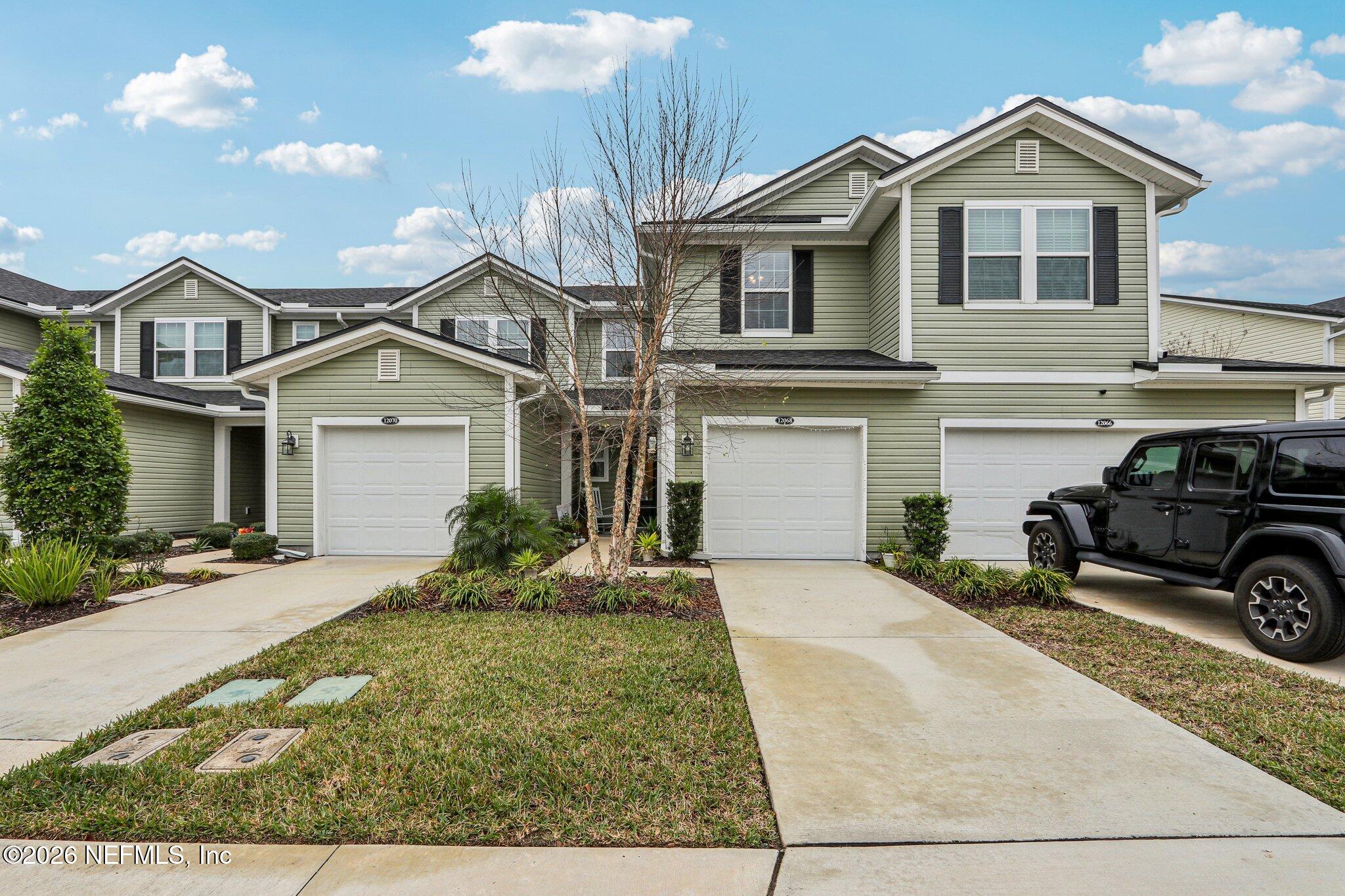 12068 Calvesta Street Jacksonville, FL 32256 - Photo 53 of 100 a front view of a house with a yard and garage