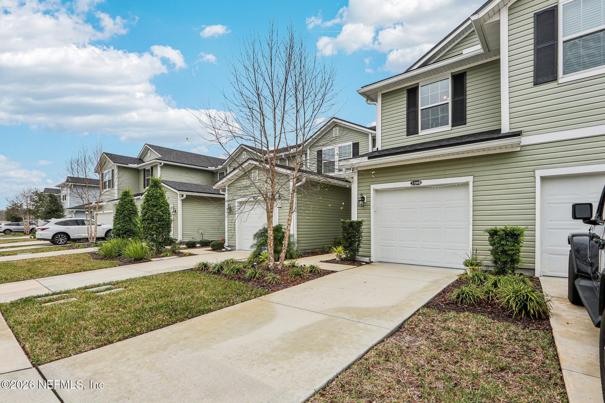 12068 Calvesta Street Jacksonville, FL 32256 - Photo 57 of 100 a front view of a house with a yard and potted plants